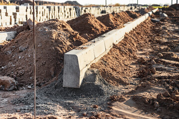 Pavement repairs and paving slabs laying on the prepared surface, with tile cubes in the background. Laying paving slabs in the pedestrian zone of the city. Paving slabs and curbs.