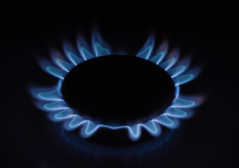 The flame of a burning gas burner in the dark.