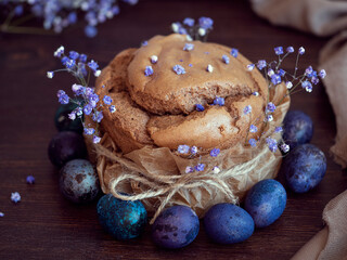 Appetizing Easter cake with a beautiful decor of flowers and with Easter eggs on craft paper