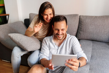 Couple using tablet computer at home