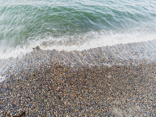 Aerial top down view on a beach with pebble and ocean wave. Salthill beach, Galway city, Ireland. Nobody.
