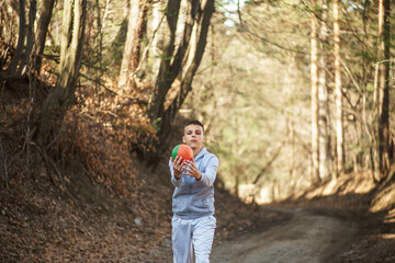 young man trains outdoor in nature, a boy athlete practices a healthy lifestyle