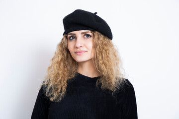 Hünsche junge Frau mit roten Locken, einem schwarzen Kleid und einem schwarzen Béret. Eine junge...