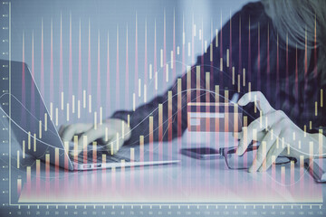 Double exposure of woman on-line shopping holding a credit card and financial graph drawing. Stock market E-commerce concept.