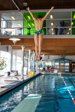 Girl jumping from diving board