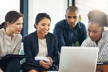 Theyre a team with a vision. Shot of a group of businesspeople talking together over a laptop...