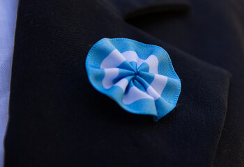 an Argentine cockade on the lapel of the jacket