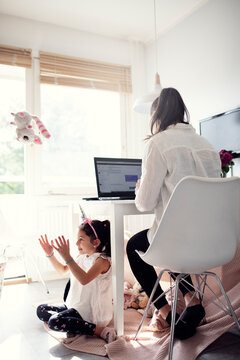Woman in kitchen using laptop