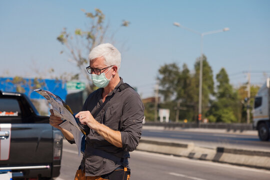Senior man in face mask using map