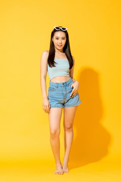 Summer portrait of Asian woman in isolated yellow studio background