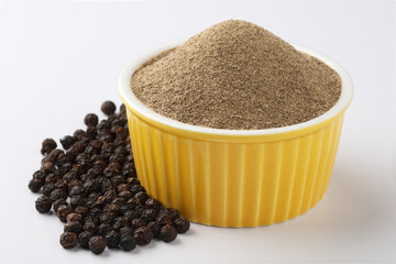 Indian spices - black pepper powder,Black pepper corns scattered on white background and Black...