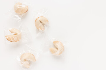 Obraz na płótnie Canvas Fresh and tasty Chinese fortune cookies, individually wrapped in foil on white background. Top view, copy space