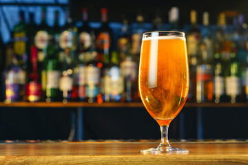 Fresh cold beer in glass on bar background