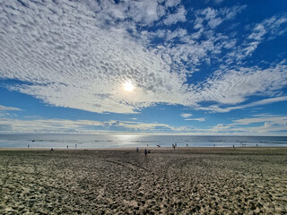 Breathtaking view from a beach against blue sky background with altocumulus clouds - obrazy, fototapety, plakaty