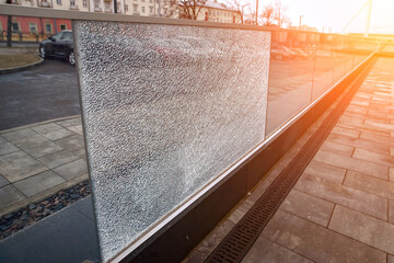 Glass fence with broken glass, damaged shockproof fencing on office terrace. Cracked glass panel,...