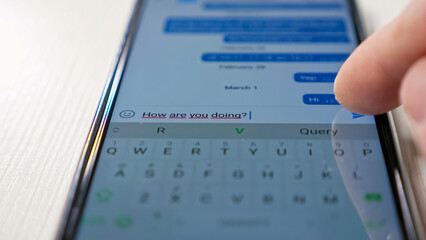 Using cellphone to send message to friend close up