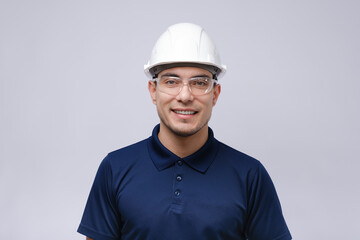 closeup portrait of smiling man architect, builder in blue T-shirt, white helmet and glasses on grey background - obrazy, fototapety, plakaty