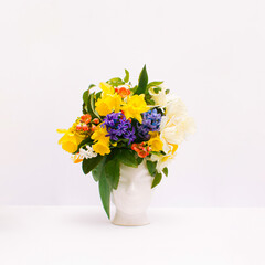 Fresh bunch of colorful flowers in human head shaped vase on white background. Card Concept, copy space for text. Creativity, nature, ecology and springtime concept.