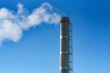 white smoke from industrial pipe against background of blue sky, environmental pollution