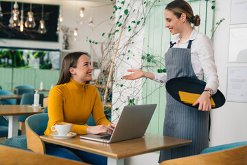 woman talking to waitress in restaurant
