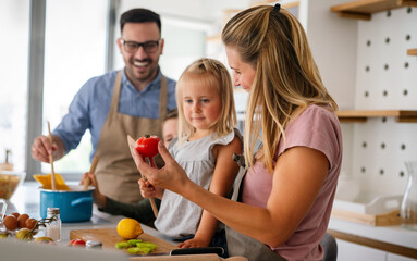 Obraz na płótnie Canvas Happy family preparing healthy food together in kitchen. People happiness cooking concept