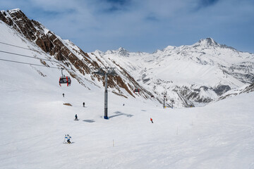 Snowy slopes with gondola and chair lift in nice sunny day. Ski resort Gudauri, Georgia. Caucasus Mountains. Wide angle view. © bortnikau