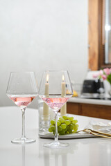 Table with two glasses of rose wine and grape