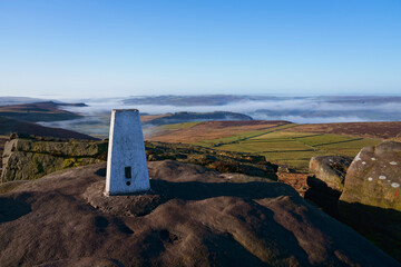 On the gristone rocks of Stanage Edge beside a triangulation station  looking across the Derbyshire...