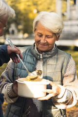 Elderly Caucasian woman getting food from a man nature background senior people wellbeing support concept medium shot selective focus . High quality photo