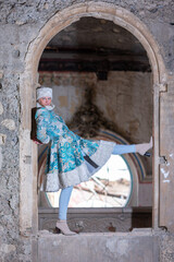 Winter queen in an abandoned castle. A beautiful woman in a winter suit