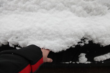 Fototapeta premium Man's hand opens snow covered car door handle from the outside