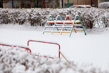 Snow covered empty kids Playground at winter snowy day - children leisure on the outdoor