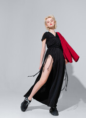 stylish blonde in a black dress with a red jacket