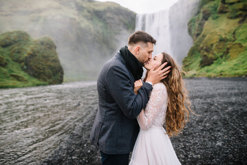 Stylish Bride and groom on elopement near Skogafoss waterfall. Iceland wedding