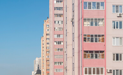 Windows and balconies of the residential building. Old urban obsolete facade of panel house. The...