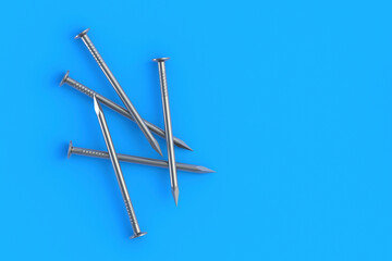 Metal nails on blue background. Building equipment. Tool for repair, renovation. Top view. Copy space. 3d render