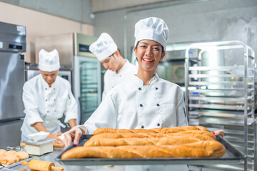 Smiling  asian young female bakers looking at camera..Chefs  baker in a chef dress and hat, cooking...