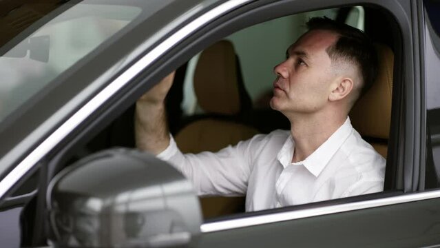 Man sitting inside vehicle in car dealership