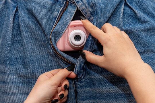 Women's Hands Unbutton Men's Jeans, A Child's Camera Sticks Out. Concept: Collection Of Compromising Material, Bed Scene, Sexy Man, Size And Preferences.