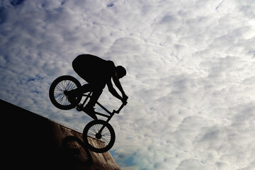 Silhouette of a young man engaged in extreme sports on a bicycle bike. High quality photo