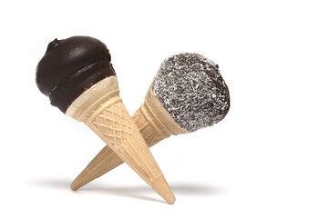 chocolate covered cream cones crossed white background