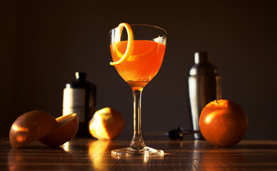 Photo of Nick and Nora orange cocktail with fresh oranges on sunsets background