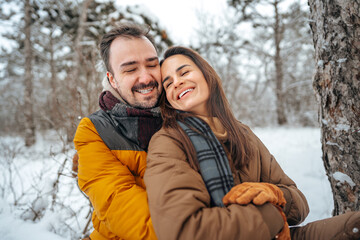 Obraz premium Young couple in love outdoor in snowy winter forest.