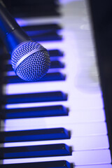Microphone over piano keys in dim light