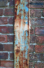 Close Up of Vertical Rusted Iron Beam in Old Brick Wall 