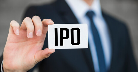 IPO letters (or Initial Public Offering) on the card held by a man hand