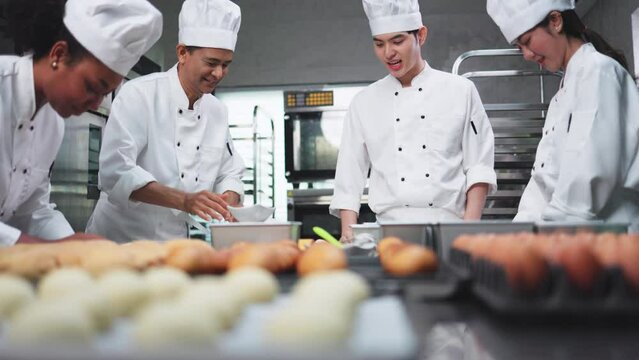 Asian Chefs  baker in a chef dress and hat, cooking together in kitchen.Team of professional cooks in uniform preparing meals for a restaurant in the kitchen.