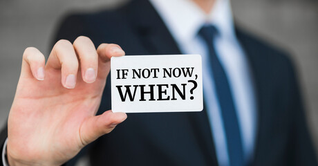 Businessman holding a card with text If not now, when