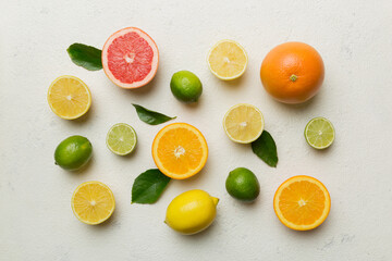 Flat lay of citrus fruits like lime, orange and lemon with lemon tree leaves on light colored background. Space for text healthy concept. Top view