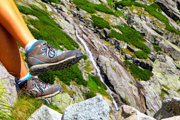 Hiking boots on leg of hiker in mountains